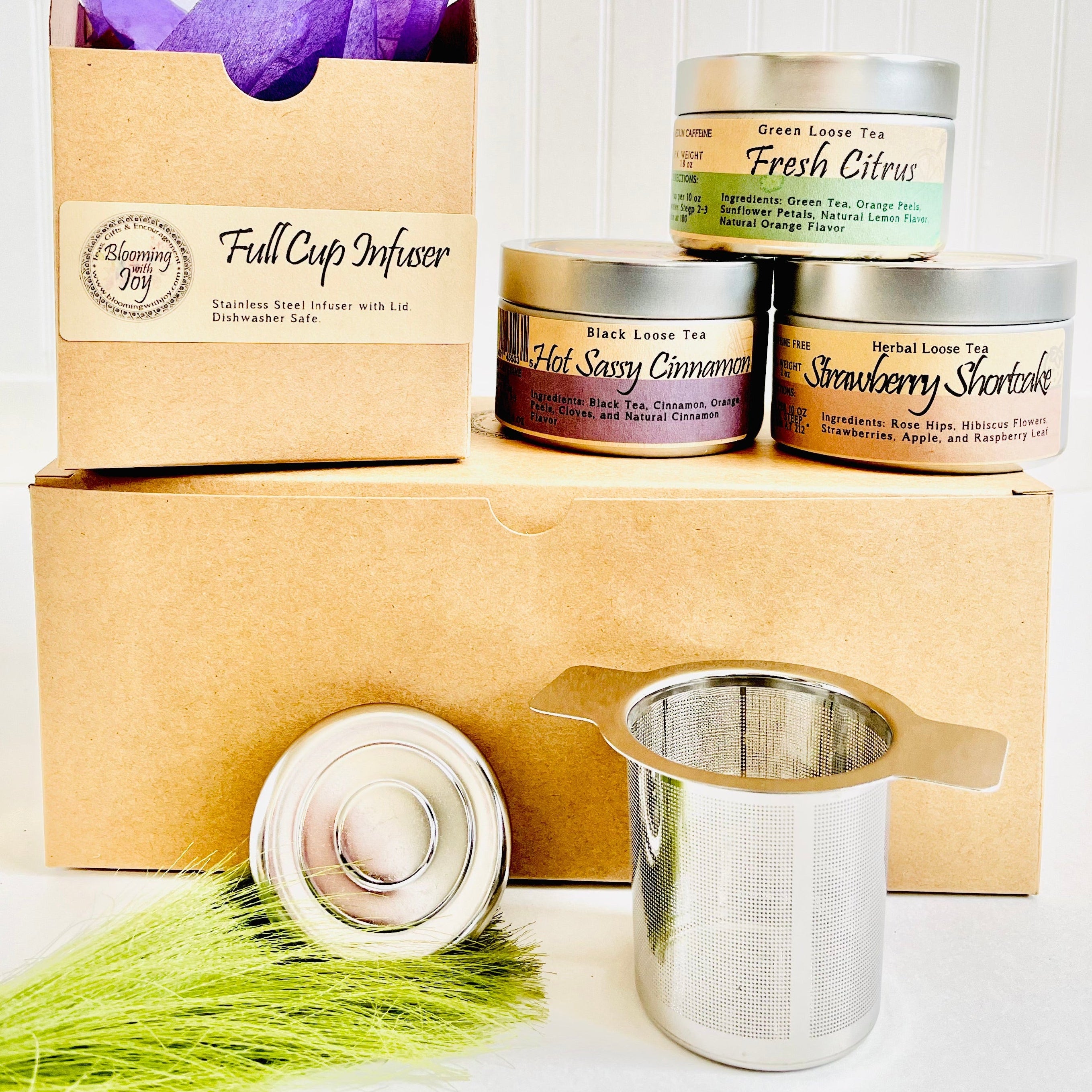 Tea packaging with 'Full Cup Infuser' and tea canisters on a white background