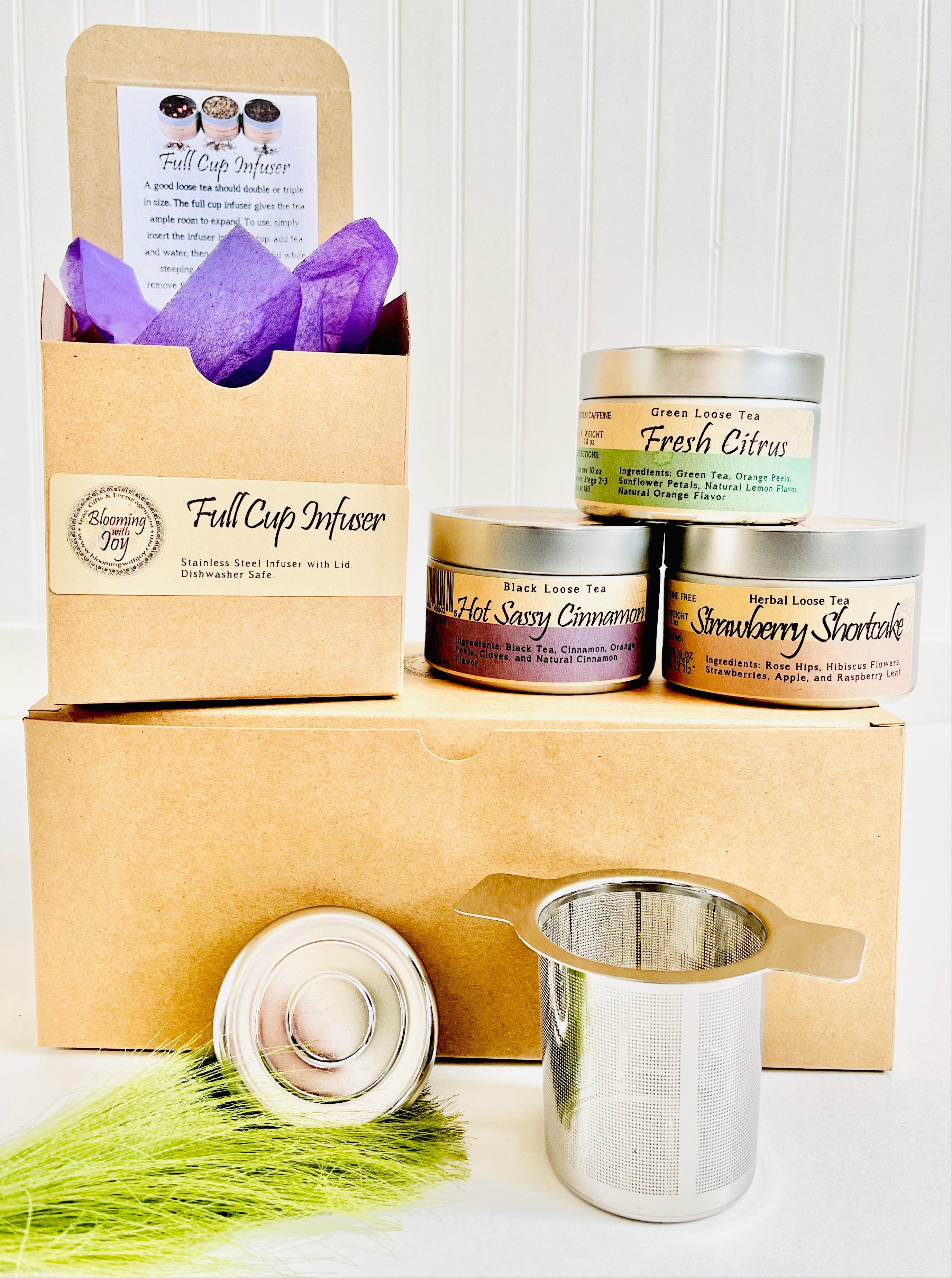 Tea packaging with 'Full Cup Infuser' and tea canisters on a white background